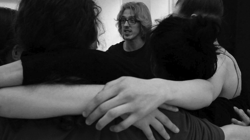 Dancers huddle up while teacher Brian Strimpel talks about the partnering class